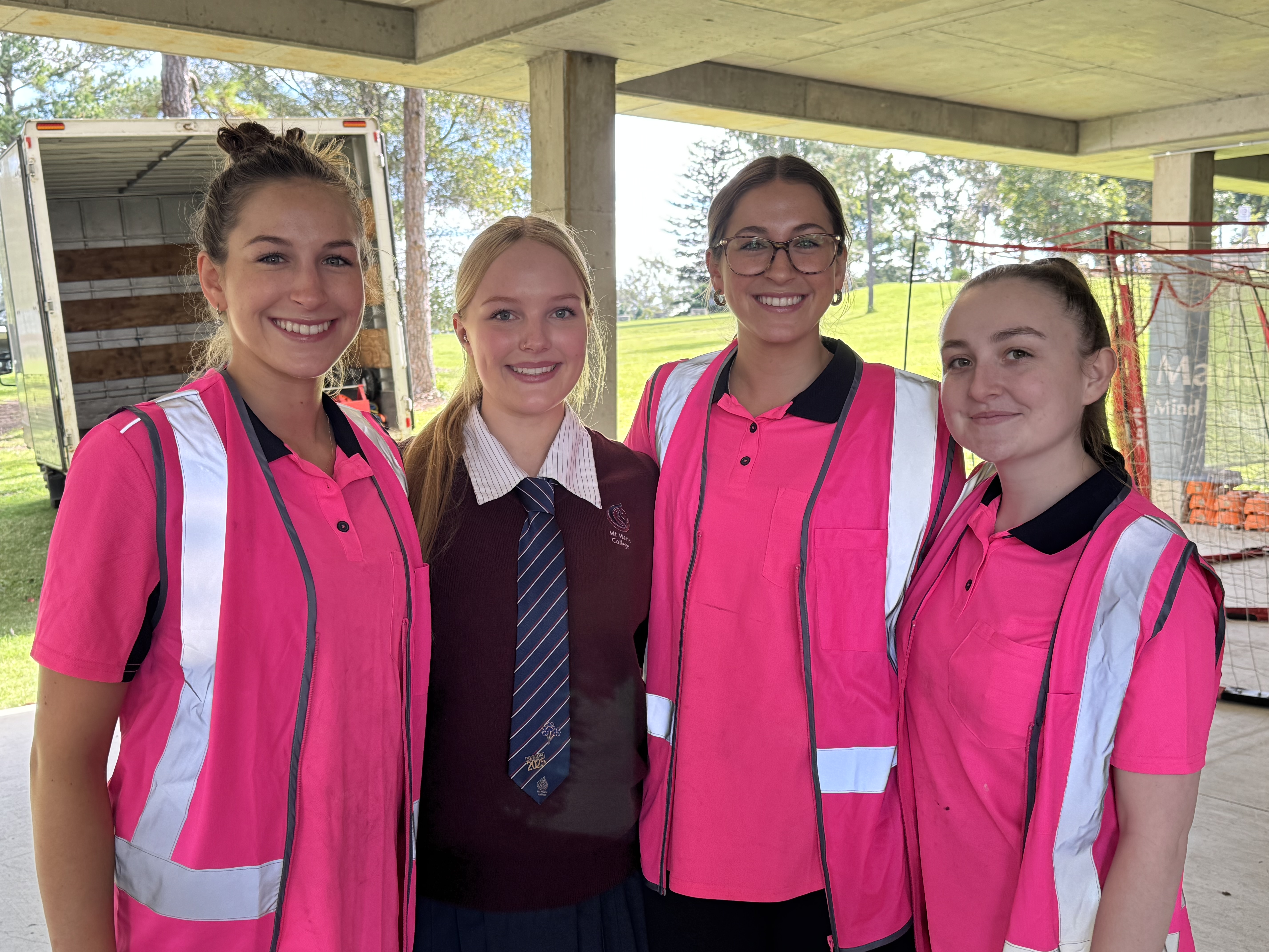 Secondary school students and an adult sort materials and equipment together in a classroom during a practical learning activity.